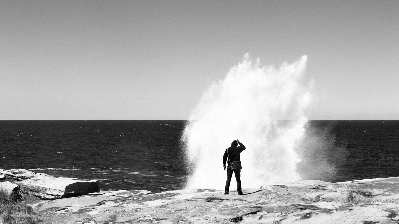 man infront of large sea spray